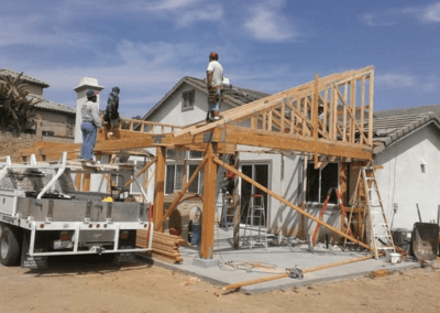 A house under construction with men working on the frame.